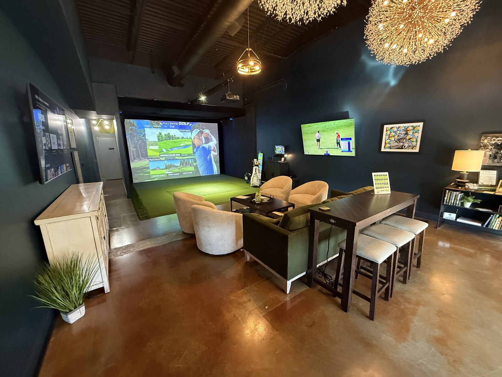Golf simulator lounge with plush chairs and chandeliers